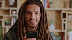 Happy man, student and typing with phone for conversation, discussion or social media in library. Male person, academic or user chatting with smile on smartphone for mobile network or communication