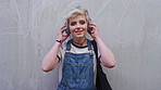 Face, woman and student with headphones outdoor for education, streaming podcast and scholarship. Wall, portrait or person with mockup space, listening to music and learning opportunity for knowledge