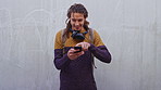 Laugh, text and man outdoor with phone, online communication and comic post on social media. Happy, space and male person on wall with technology, funny message or meme reaction on chat app.
