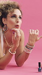 Woman, nail polish and blow on hands in studio, retro style or cosmetics on pink background. Happy person, drying and painting fingernails on floor, relax or manicure with thinking in vintage fashion