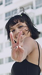 Face, peace sign and kiss with woman in city for flirting, playful attitude or style. Building, emoji and smile of happy person outdoor in urban town for hand gesture or reaction to summer fashion