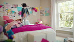 Jump, bed and happy child in home with fun, energy and excited for holiday, game or weekend. Bounce, good mood and back of kid with childhood, funny and celebration for morning in creative bedroom