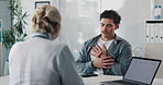 Checkup, doctor and patient talking of chest pain, heart or hypertension advice in medical office. Healthcare, evaluation and people listening for symptoms, discussion of treatment or diagnosis