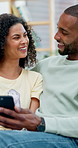 African couple, scroll and laugh with phone for social media, meme or bonding in living room of home. Man, woman and relax with smile on tech for communication, humor or love on sofa for gossip story