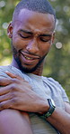 Shoulder, fitness and black man with arm injury in nature for outdoor exercise, accident or strain. Active, male person or sore joint with inflammation or massage for muscle tension or discomfort