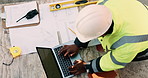 Construction, laptop and above of man for planning, building design and report for renovation. Civil engineer, desk and person with documents and tech for floorplan, blueprint and infrastructure