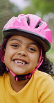 Happy, face and child in park with helmet, having fun or head protection with summer hobby. Smile, active and girl with safety gear, positive attitude and injury prevention in outdoor activity.