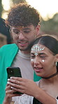 Couple, phone and happy at festival, outdoor and glitter with texting, bonding and summer holiday. People, partner and discussion with typing, contact or mobile app for social network on spring break