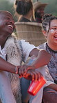 Friends, laugh and bonding in nature, camping and talk with people on vacation and social gathering. Outdoor, campfire and group with alcohol on holiday, discussion or clapping with smile at festival