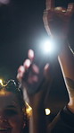 Flashlight, dance and friends with phone at festival, party and listening to music concert together. Bokeh, night and people with light for celebration, social gathering and happy for festive season