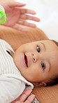 Happy, relax and face of baby in home with playing, fun or early childhood development with toy. Rattle, smile and portrait of kid in nursery room for fun, growth and calm on weekend in apartment.