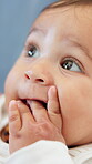 Teething, baby and chewing fingers in home, thinking and child with sensory development or milestone. Infant, cognitive growth and biting hand for gum relief, wellness and self soothing in house