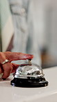 Hospitality, bell and hands in hotel with tap, arrival system or assistance at reception counter. Entry, person or guest at lodge with inquiry, support alert or service notification at front desk.