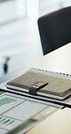 Notebook, paperwork and desk in empty office with charts, graphs or statistics for finance report. Journal, documents and diary for financial project with investment research for career in workplace.