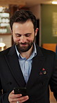 Phone, walking and business man in hotel for travel reservation, thinking or online check in. Mobile, smile and guest in accommodation for booking, hospitality service and reflection in lobby