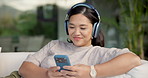Headphones, dancing and Asian woman with phone on couch, weekend radio and streaming music playlist. Smile, audio tech and person with web search for nostalgic track, home and moving to song beat