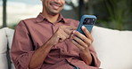 Happy, man and hands typing with phone on sofa for social media, communication or online texting. Male person, user or scrolling with mobile smartphone or smile for network connection or chat in home