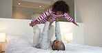 Dad, child and lift with play on bed with smile, bonding and connection with airplane game in morning. People, father and boy with fun, flight or love with care, laugh and plane at family house