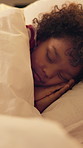 Sleeping, tired and child in bed at night for resting, dreaming and comfortable in home. House, dark and girl with blanket, pillow and duvet for peaceful evening, calm or asleep for energy on weekend