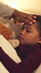 Hand, forehead and child in bed with fever, virus and viral infection with parent for medical care. Family, home and girl at night with high temperature, flu symptoms and health concern in bedroom
