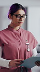 Woman, nurse and folder for reading in hospital for research, schedule update or healthcare information. Medical employee, file and glasses or serious for paperwork, report or treatment history