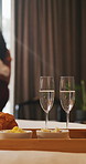 Champagne, food and tray of breakfast in hotel for room service, anniversary or romantic holiday. Sparkling wine, fruit and croissants for morning meal in accommodation for honeymoon vacation.