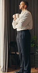 Thinking, window and businessman in hotel with coffee for decision, reflection and ideas on work trip. Hospitality, travel and person with drink for thoughtful, wondering and solution in morning