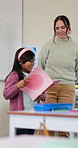 Teacher, student and child with reading book in classroom,  education and practice for literacy skills. Smile, educator and girl with literature for knowledge development, storytelling and speaking