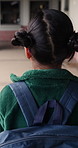 Walking, back or girl with backpack in school for curriculum, academic development or lesson journey. Education, student or child with bag for learning, knowledge growth or academy hallway for future