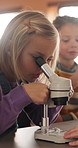 Education, science and child with microscope in class for development, knowledge or study. Kid, microbiology and learning with equipment in lab lesson, students and research experiment at school