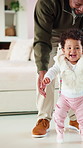 Father, baby and happy for learning to walk in home with balance, guidance or child development. Dad, excited kid or encourage first steps with teaching mobility, physical milestone or healthy growth