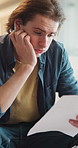 Man, paperwork and stress in home for debt, eviction letter or financial decision on sofa. Worried, mistake and person with anxiety, risk and documents for budget, mortgage or loan rejection