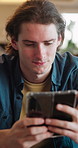 Man, chill and typing in living room with phone, check online dating profile and social media update. Person, relax and scroll in home with tech, internet connectivity or mobile app for text message.