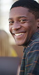 Student, face and happy man in library for education, learning and study with laptop for assignment. Portrait, laughing and planning for exam with friends, talk and people with textbook for knowledge