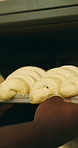 Chef, hands and dough in oven with croissant preparation, cooking process or catering in bakery kitchen. Hospitality, person and baking pastry in diner with food production, recipe or culinary skills