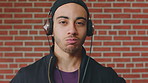 Man, face or student with headphones for music, audio streaming or development on a wall background. Portrait, male person or academic learner with sound for enthusiastic DJ or inspiration in college