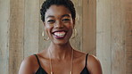 Black woman, laugh and face at wall in office with joke, memory and confidence at creative agency. African person, happy and smile in portrait with pride, excited and career at startup in Nigeria