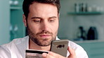 Phone, payment and man with credit card in home for online shopping, banking or purchase. Male person, shopper or smile with smartphone or debit for mobile app, ecommerce or wireless transaction