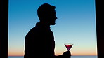 Silhouette, thinking and man with drink by window, weekend celebration and me time for reflection. Alcohol, perspective and calm person with view for stress management, remember memory and home