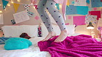 Energy, jumping and legs of child on bed in home for playing, fun and movement with blanket. Childhood, bedroom and excited girl with game, toys and pillows for holiday, weekend and break in morning