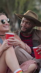 Drinks, chat and couple of friends at festival for relax, social gathering and laugh together outdoor. Party, group and people with alcohol at event, happy and hangout with funny joke for celebration