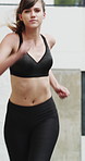 Running, fitness and woman in city for exercise, cardio workout and training for sports in morning. Runner, athlete and person with active hobby for wellness, health and endurance for speed in town