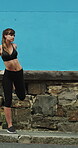 Runner, earphones and warm up with woman in city for streaming service, health podcast and cardio. Wellness, exercise playlist and training music with person outdoor for audio, stretching and radio