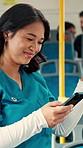 Woman, nurse and texting with phone in bus for commute, smile and notification for chat on travel. Person, medical professional and scroll with mobile app, contact or social media in public transport