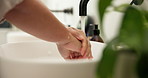 Person, water and washing hands with tap in sink for hygiene, disinfection or cleanliness in home. Closeup, faucet or cleaning dirt in basin for skin protection, bacteria or germ removal in house