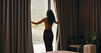 Curtains, open and woman wake up in hotel with morning, holiday and luxury for hospitality. Bedroom, back and person by window with accommodation for ready, weekend plans or start day on vacation
