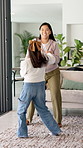 Dancing, holding hands and mother with girl in living room, bonding and smile for healthy relationship. Support, happy woman and child with music for family fun, jump and moving together in home