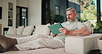 Tablet, relax and scroll with man on sofa in home for social media post, chat forum and ebook app. Digital library, blog article and weekend break with mature person in living room of apartment