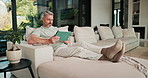 Man, online and relax with tablet in lounge, streaming and searching for movies on website in house. Chilling, mature person and browsing with app subscription, entertainment or watching film in home