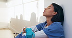 Tired, nurse and sad with woman in hospital for medical burnout, stress and thinking. Healthcare mistake, reflection and challenge with frustrated person on floor of clinic for fatigue and grief